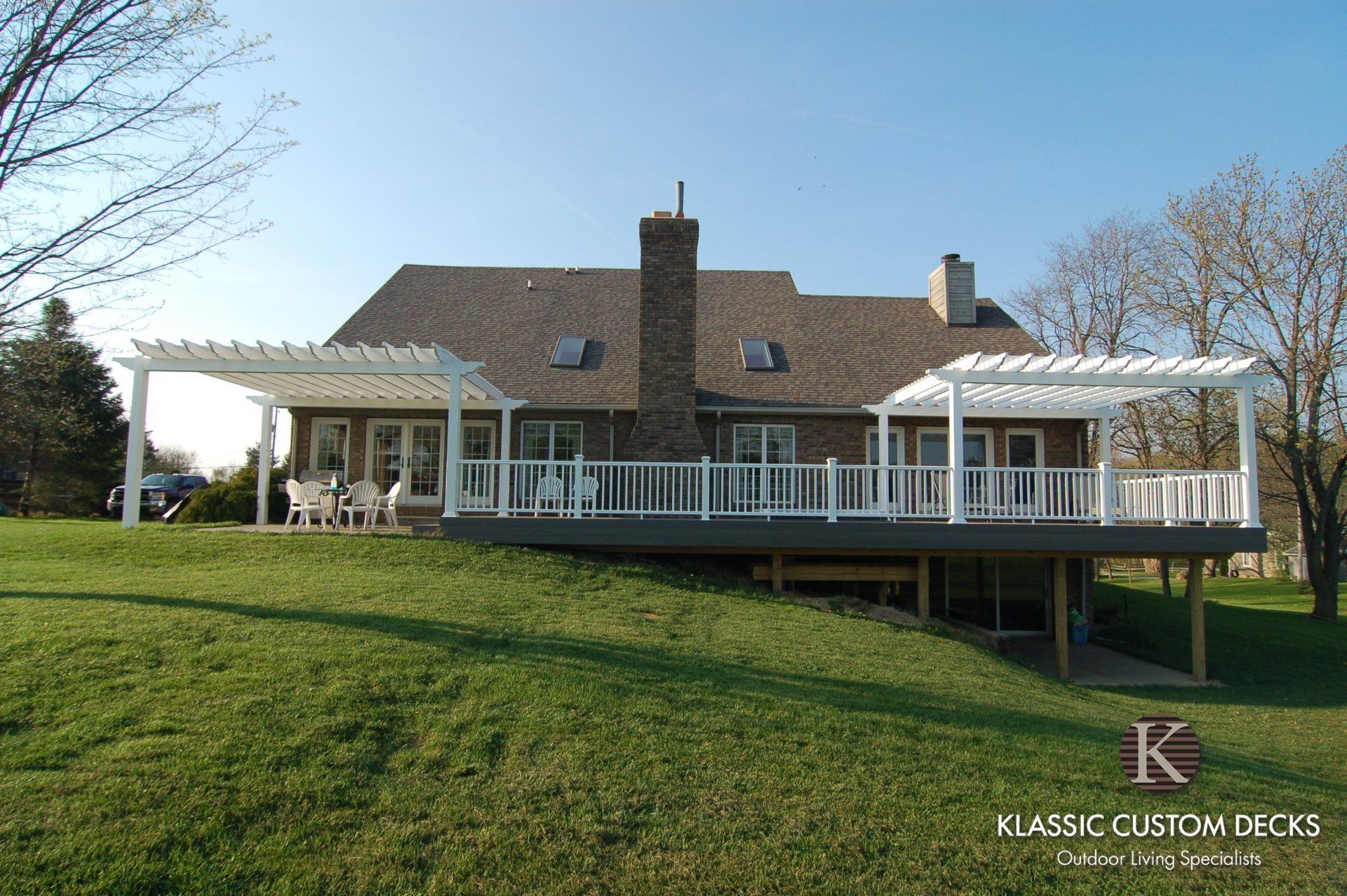 Single-story house with white porch and green lawn on a sunny day