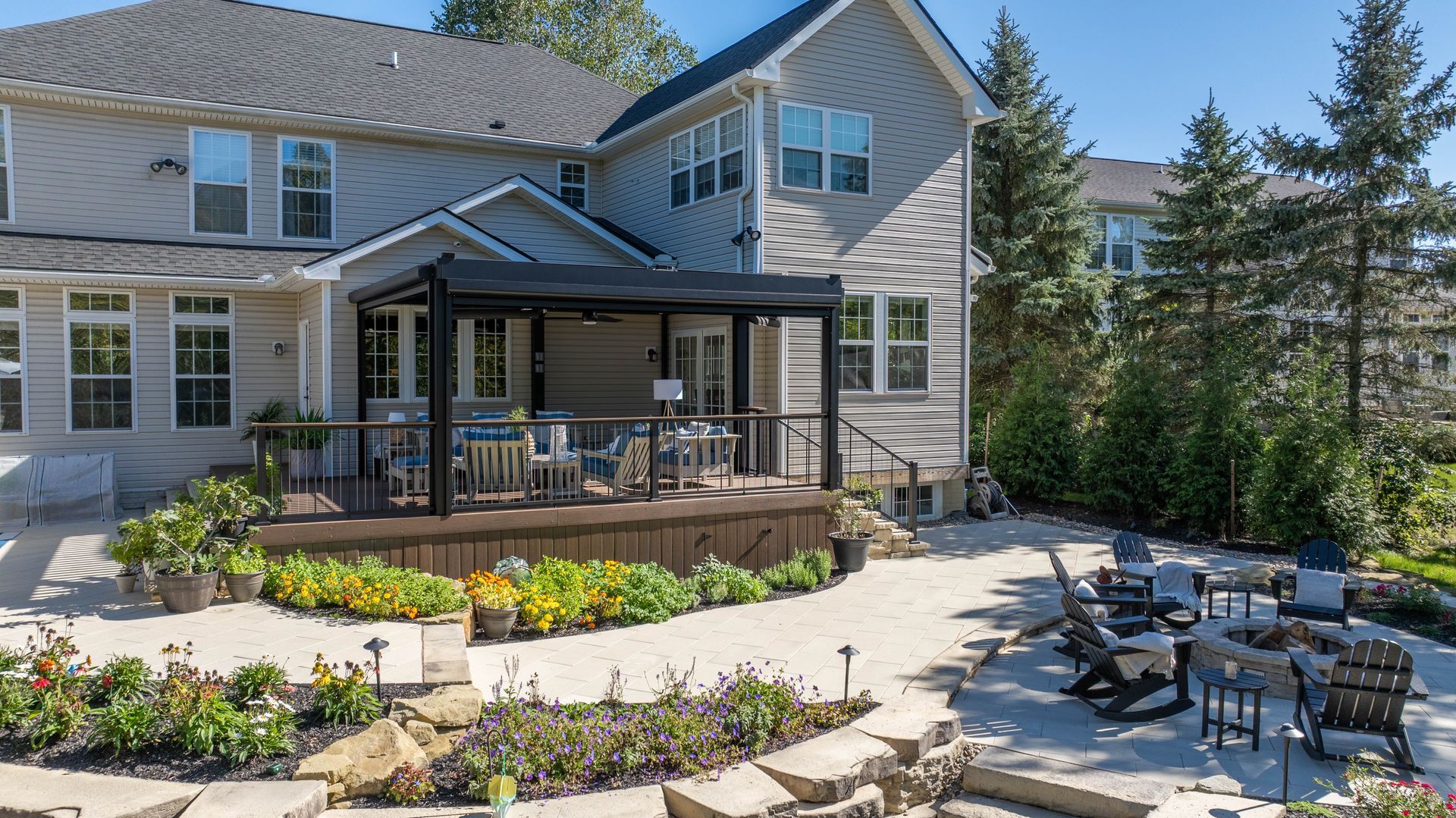 Modern house with a covered patio, landscaped garden, and outdoor seating area