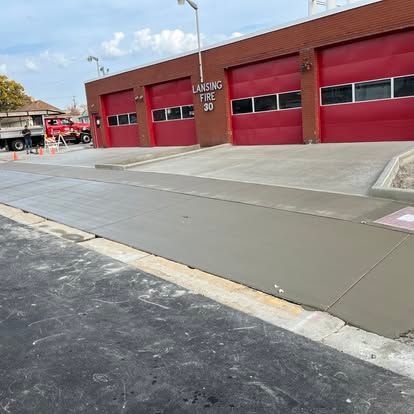 Fire station with red doors; fresh concrete sidewalk and driveway in front. Fire station with red doors; fresh concrete sidewalk and driveway in front.