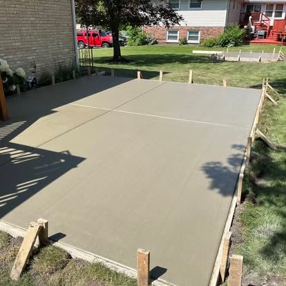 Freshly poured concrete patio with wooden framing in a backyard. Freshly poured concrete patio with wooden framing in a backyard.