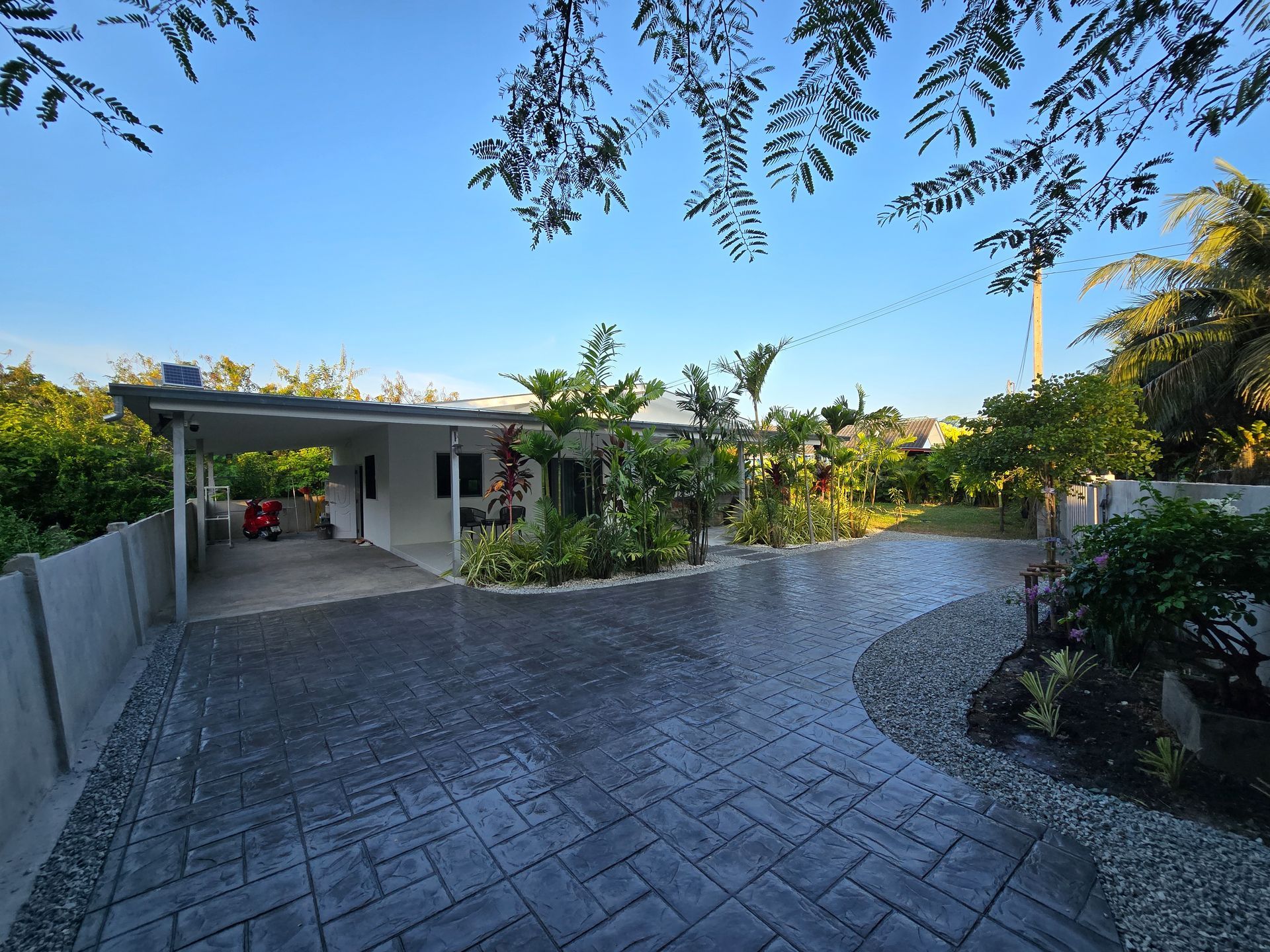 Stamped concrete driveway leading to a landscaped residential home