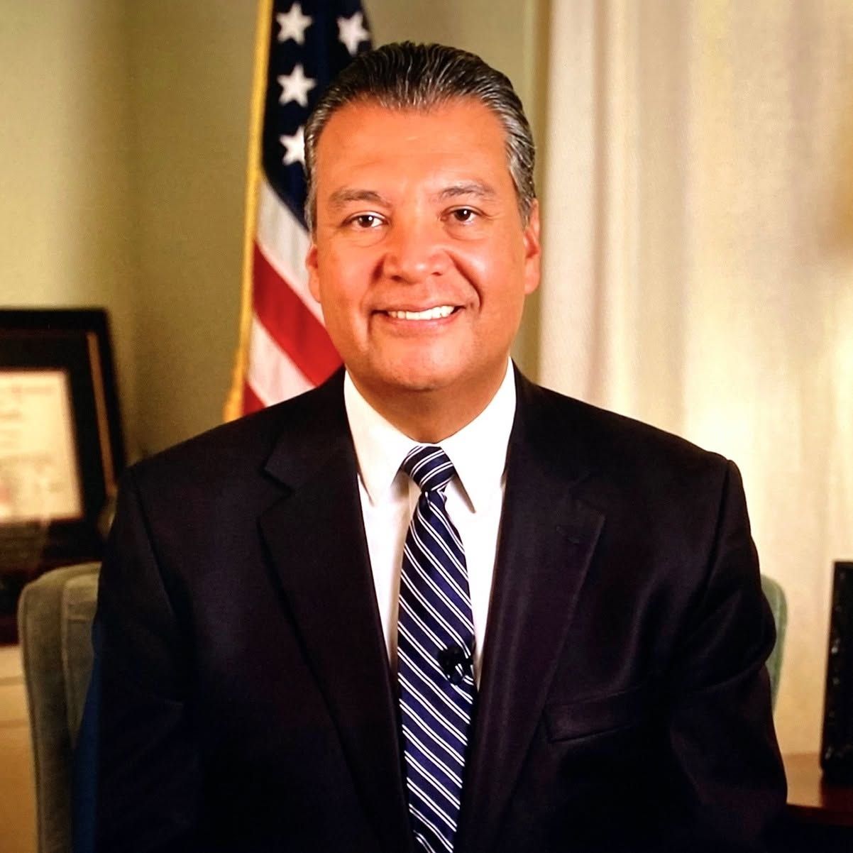 A man in a suit and tie is smiling for the camera.
