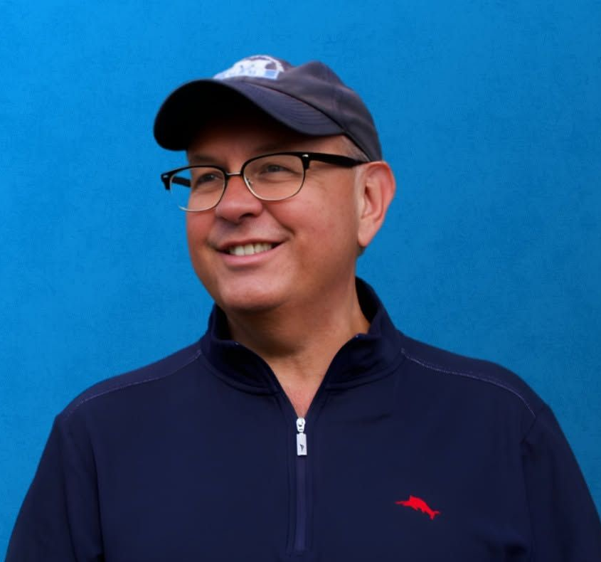 Man wearing a blue hat is smiling away from the camera.