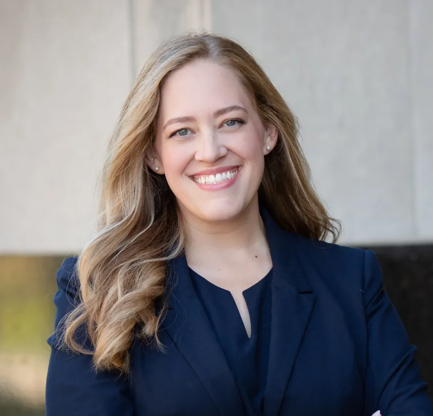 Woman in a blue suit is smiling at the camera.