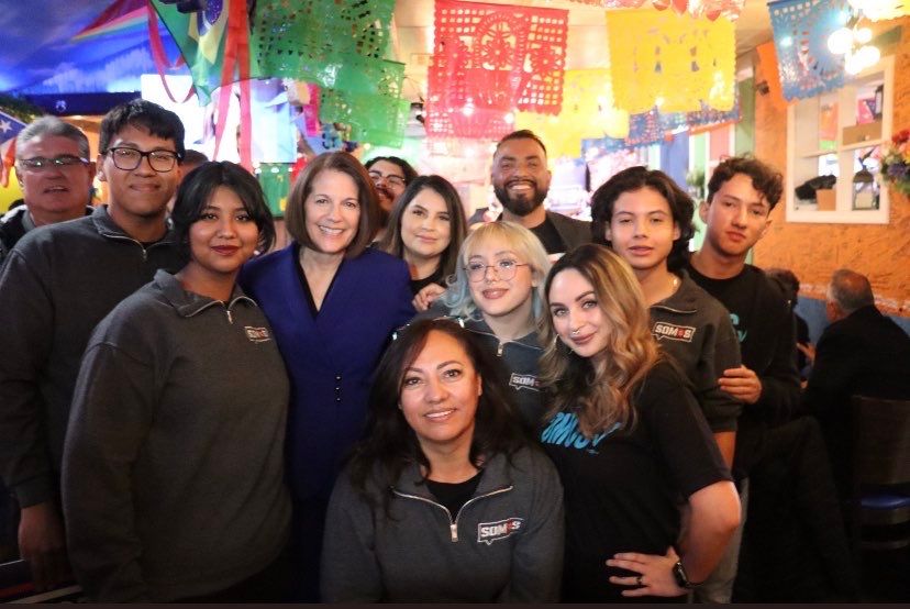 A group of people are posing for a picture in a restaurant.