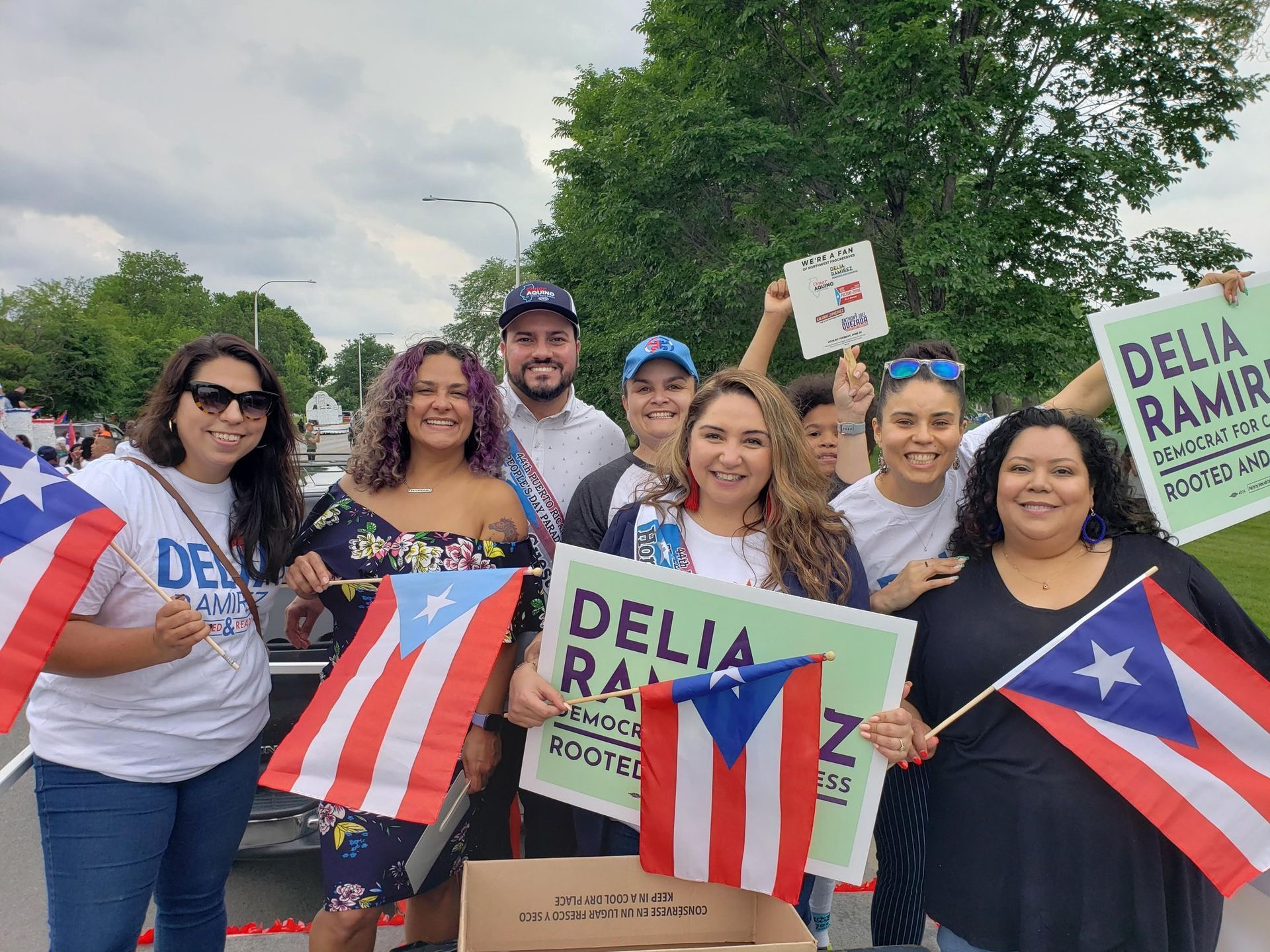 A group of people are standing next to each other holding flags and signs.