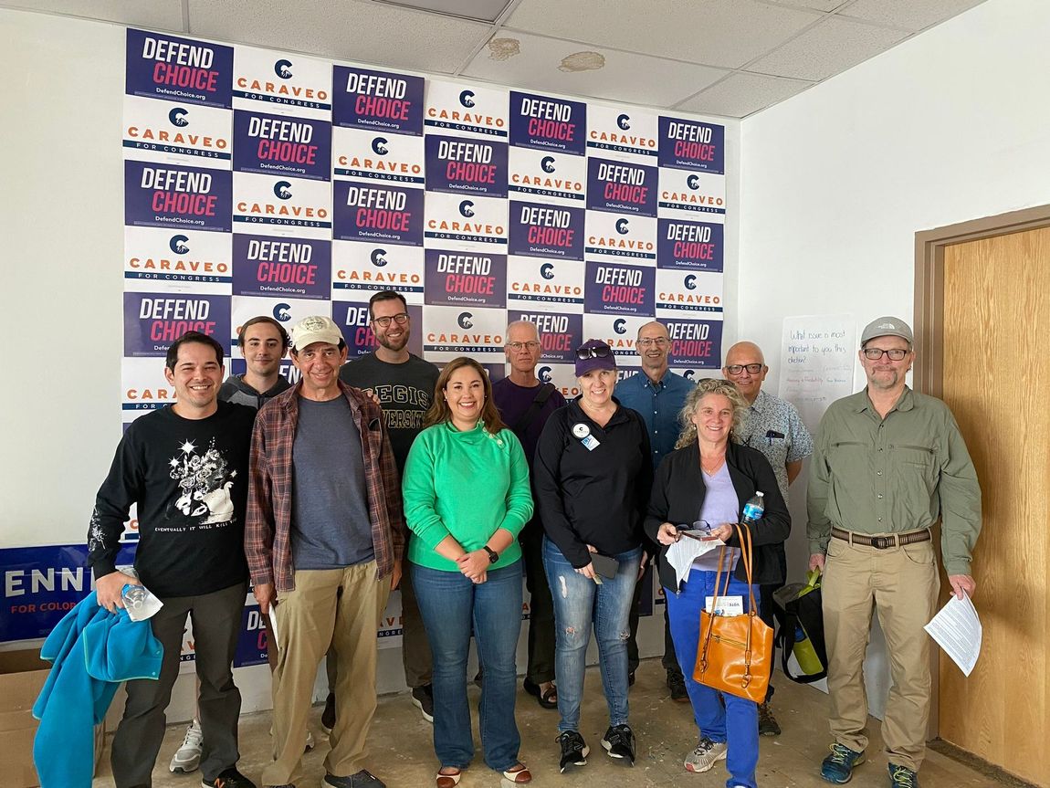 A group of people standing in front of a wall that says seven oasis