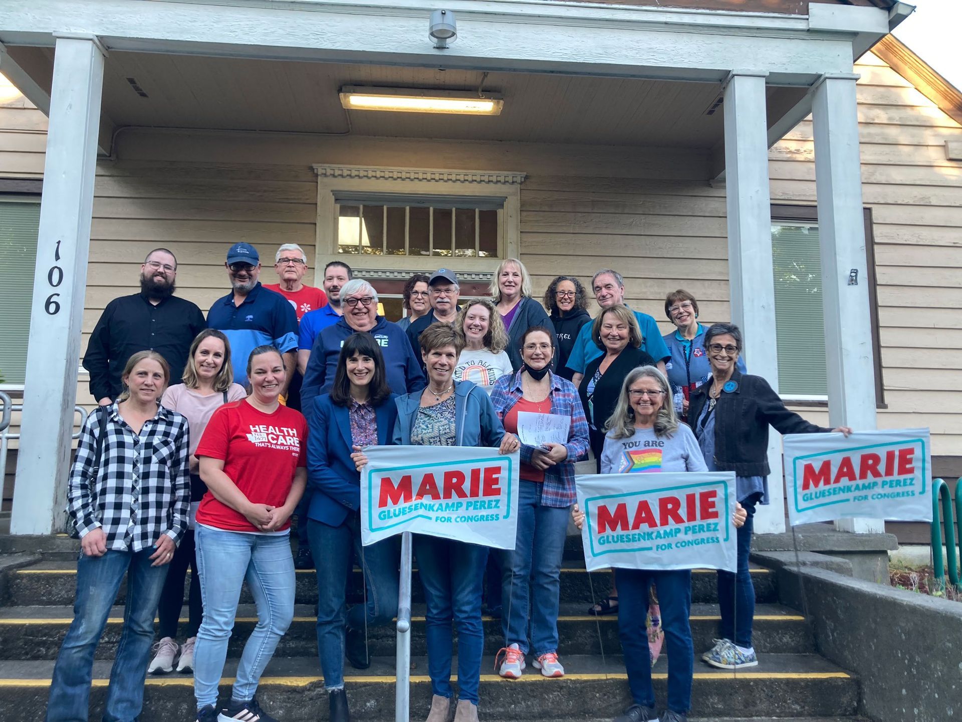 A group of people standing in front of a building holding marie signs.