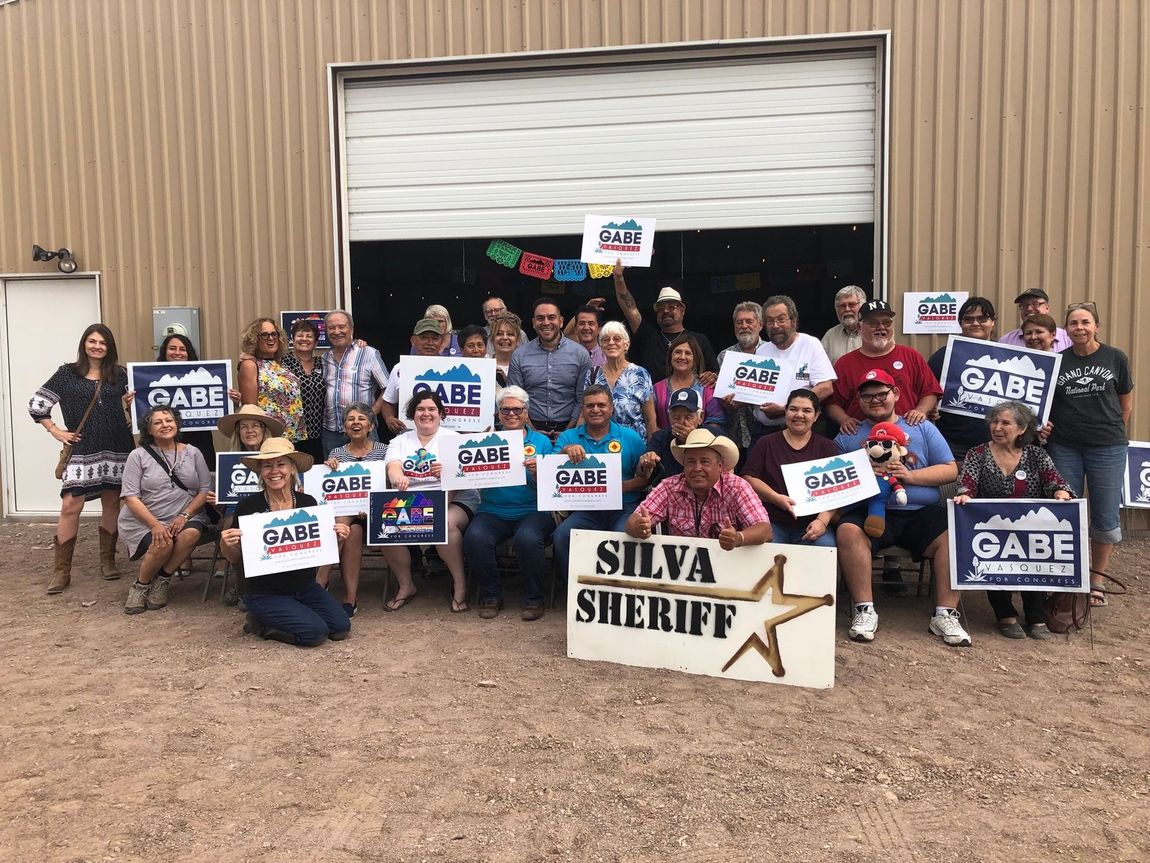 A group of people standing in front of a building holding signs.