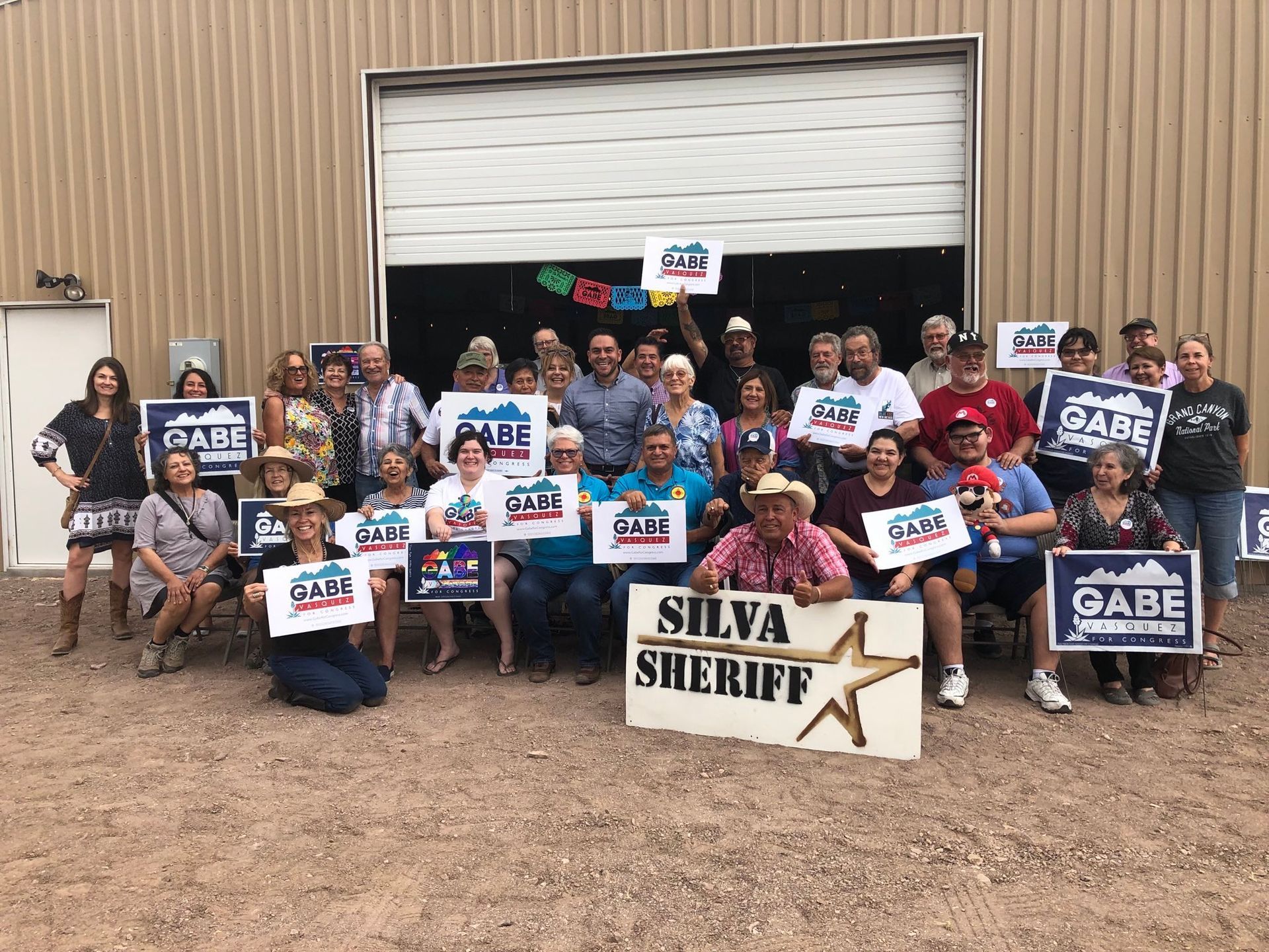 A group of people standing in front of a building holding signs.