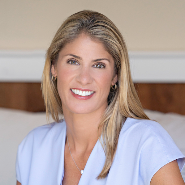 A woman in a blue shirt is smiling for the camera