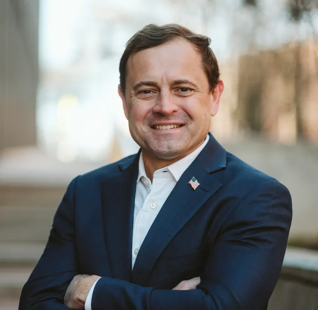 A man in a blue shirt is smiling for the camera.