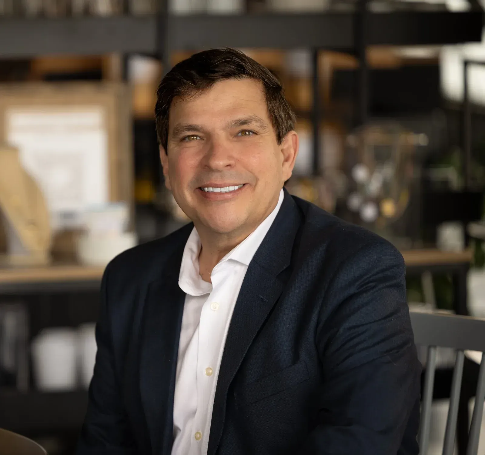 A man in a suit and tie is smiling for the camera