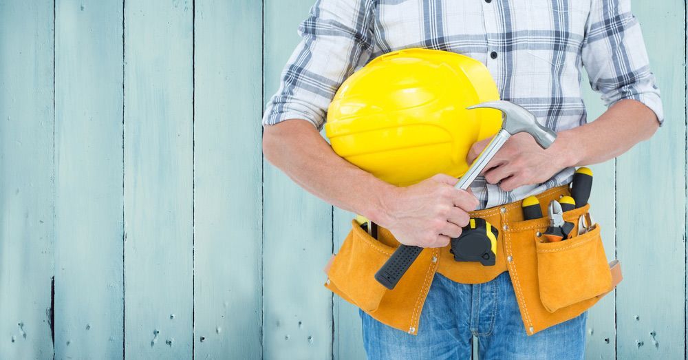 Carpenter Torso With Hammer Against Blue Wood Panel — Building Supplies in Scone, NSW