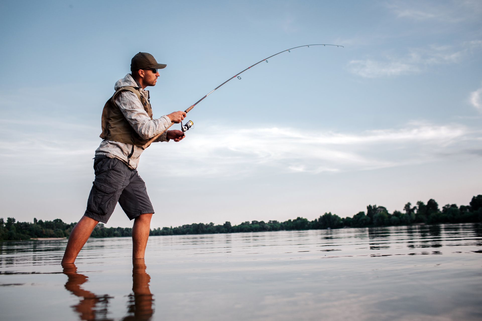A man is fishing in the water with a fishing rod.