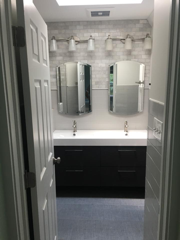 Bathroom with a double vanity. Black cabinet, white countertop, and two mirrors.