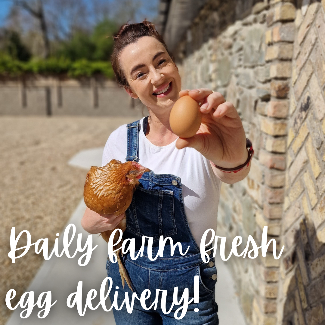 A woman in overalls is holding a chicken and an egg.