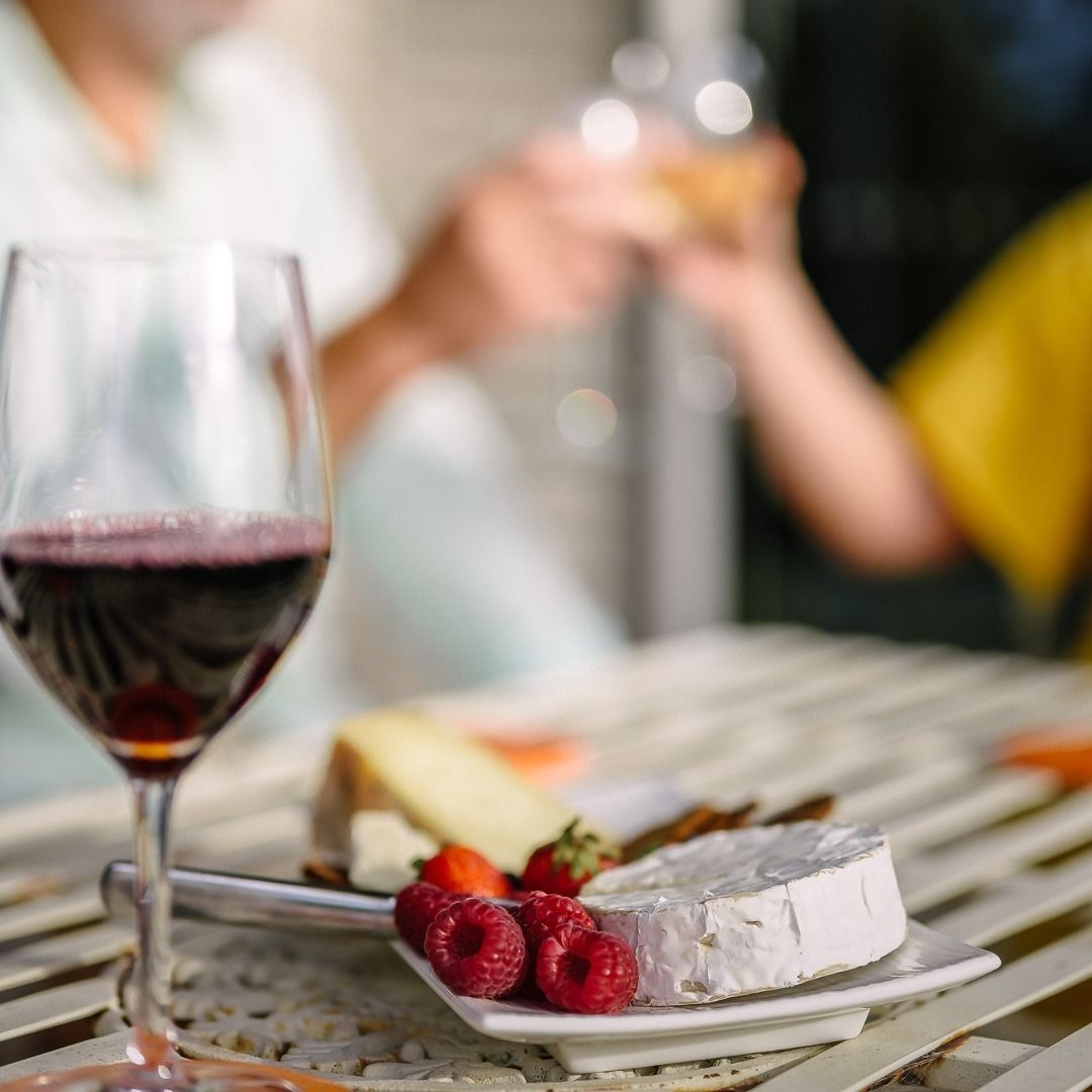 A Bottle of Wine and Two Glasses of Wine Are on a Glass Table — Lakeview Luxury Retreat in Canobolas, NSW