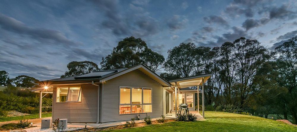 A Small House is Sitting on Top of a Lush Green Hill Surrounded by Trees — Lakeview Luxury Retreat in Canobolas, NSW