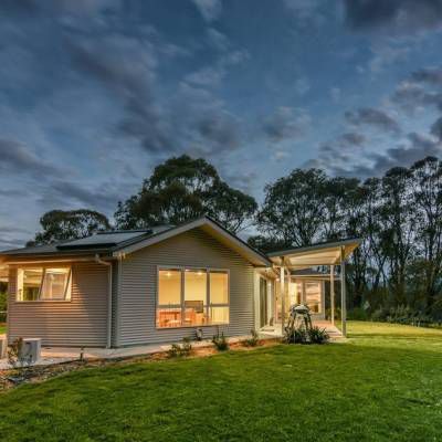 A Small House is Sitting in the Middle of a Lush Green Field — Lakeview Luxury Retreat in Canobolas, NSW