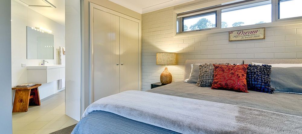 A Bedroom With a Large Bed and a Bathroom in the Background — Lakeview Luxury Retreat in Canobolas, NSW