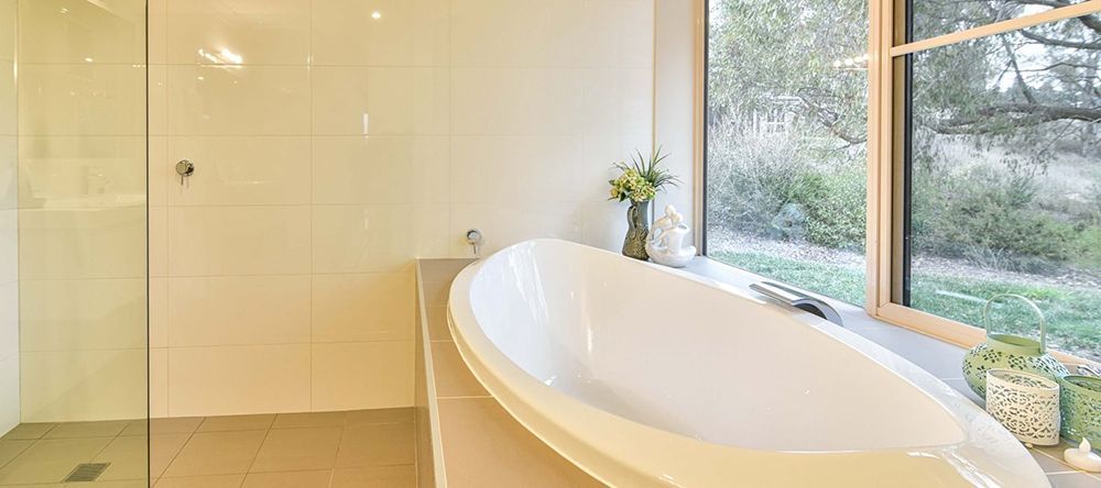 A Bathroom With a Bathtub, Shower, and Window — Lakeview Luxury Retreat in Canobolas, NSW