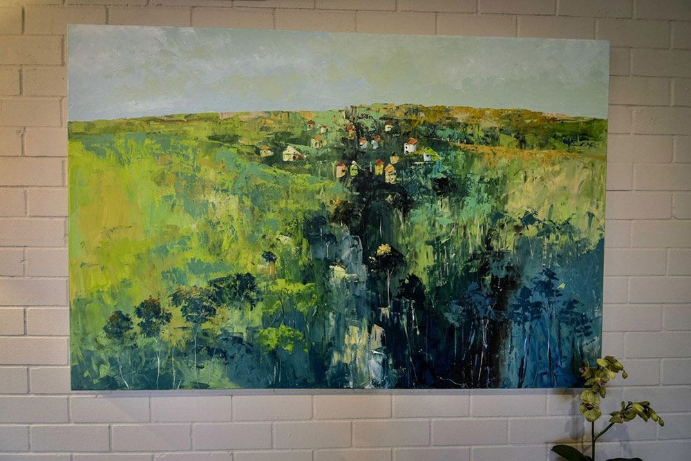 A Large Painting of a Field is Hanging on a White Brick Wall — Lakeview Luxury Retreat in Canobolas, NSW