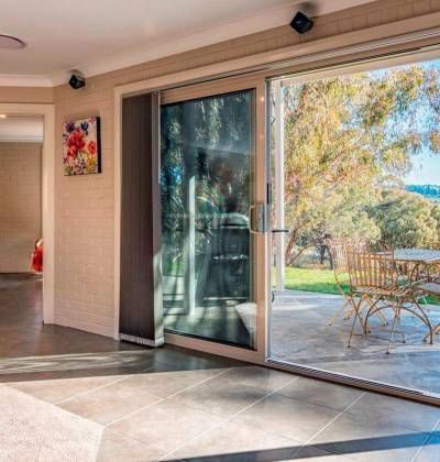 A Living Room With a Sliding Glass Door Leading to a Patio — Lakeview Luxury Retreat in Canobolas, NSW