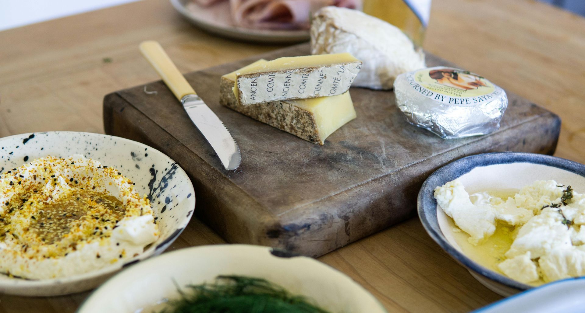 Charcuterie Board with Various Cheeses, Dips, and Knife on A Wooden Table — Lakeview Luxury Retreat in Canobolas, NSW