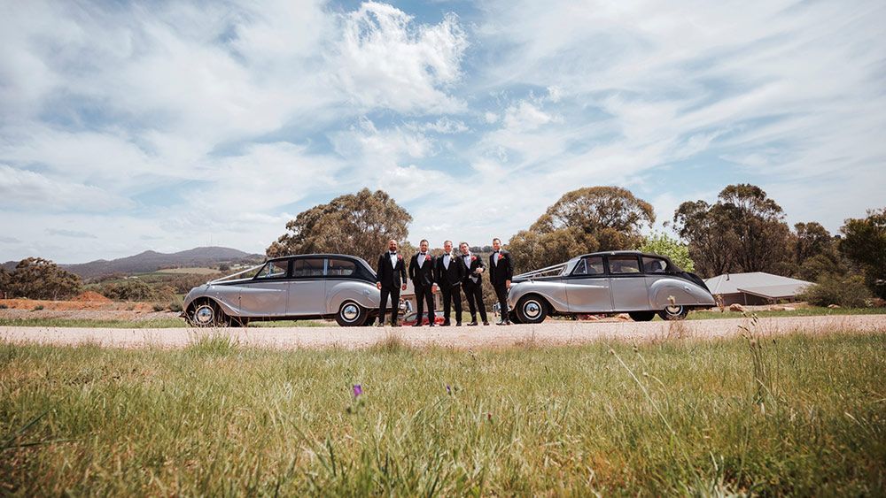 A Group of People Standing Next to Two Silver Cars on a Dirt Road — Lakeview Luxury Retreat in Canobolas, NSW