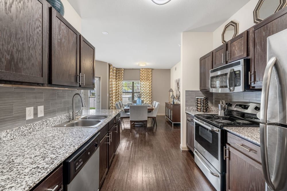 a kitchen with stainless steel appliances and granite counter tops at Marquis on Lakeline in Cedar Park, TX.
