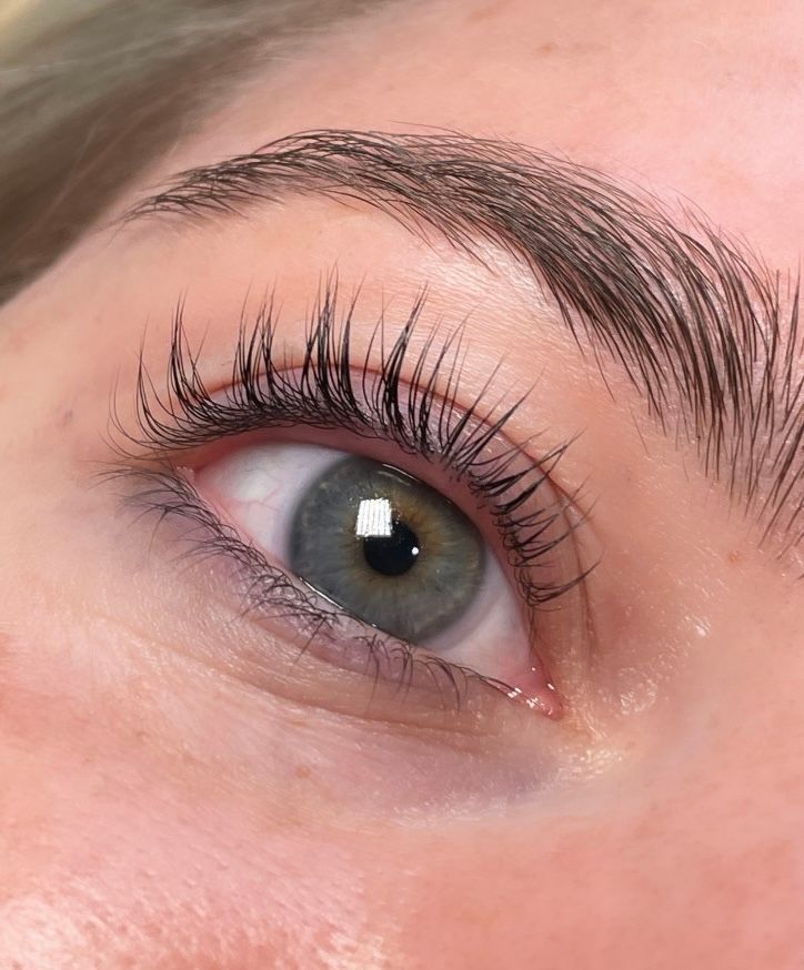 A close up of a woman 's eye with long eyelashes.