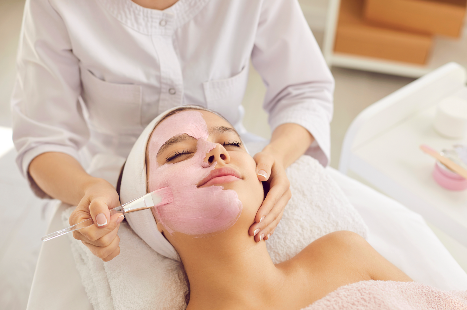 A woman is getting a facial treatment at a spa.