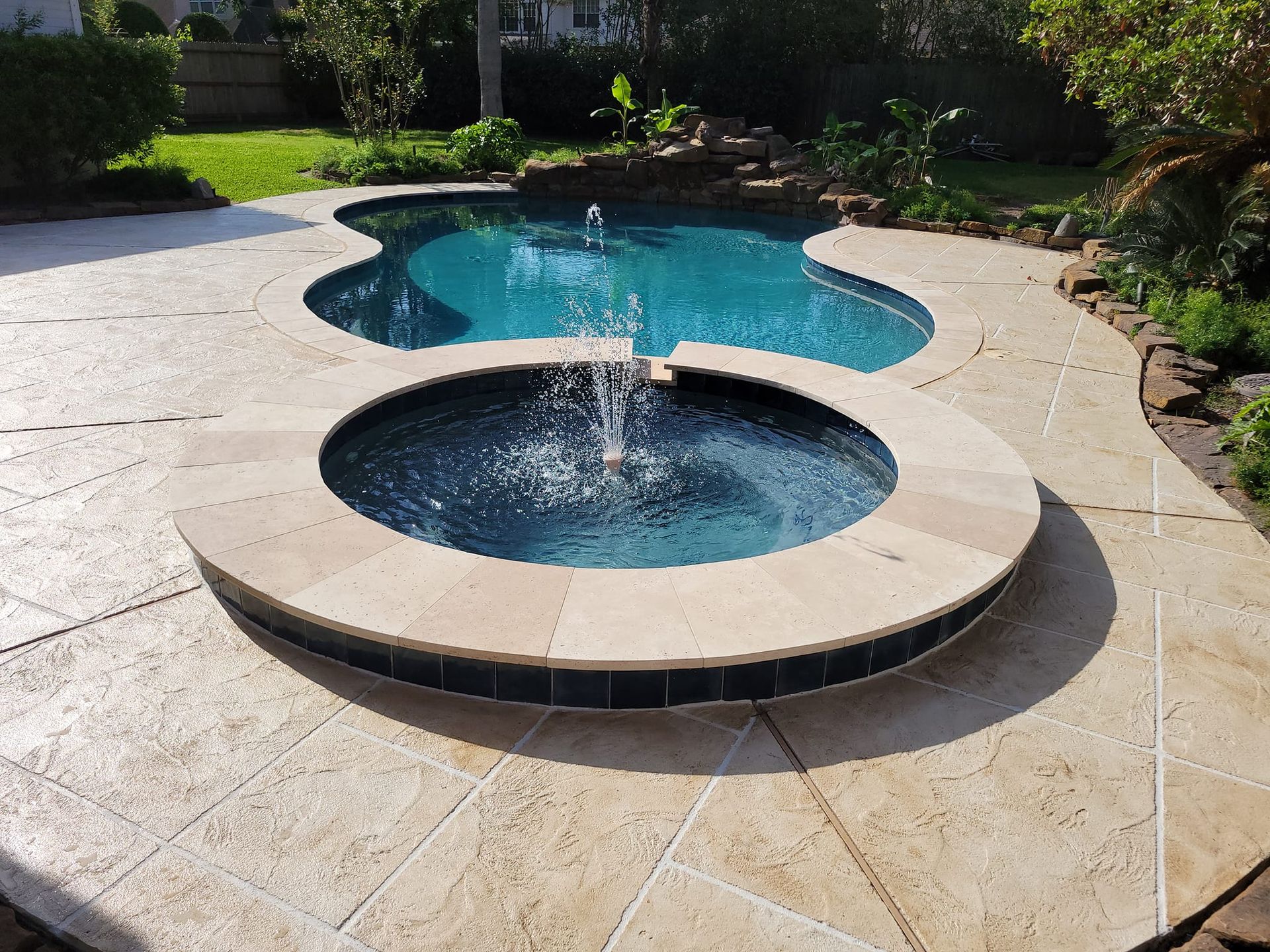 A swimming pool with a fountain in the middle of it
