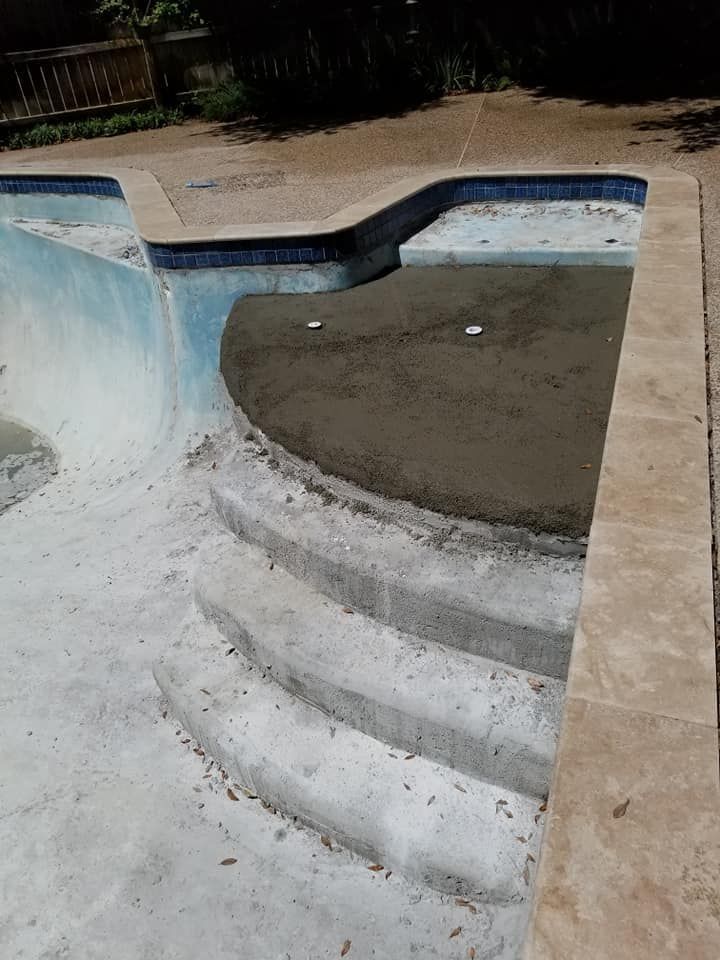 Empty drained swimming pool with peeling blue paint and concrete steps