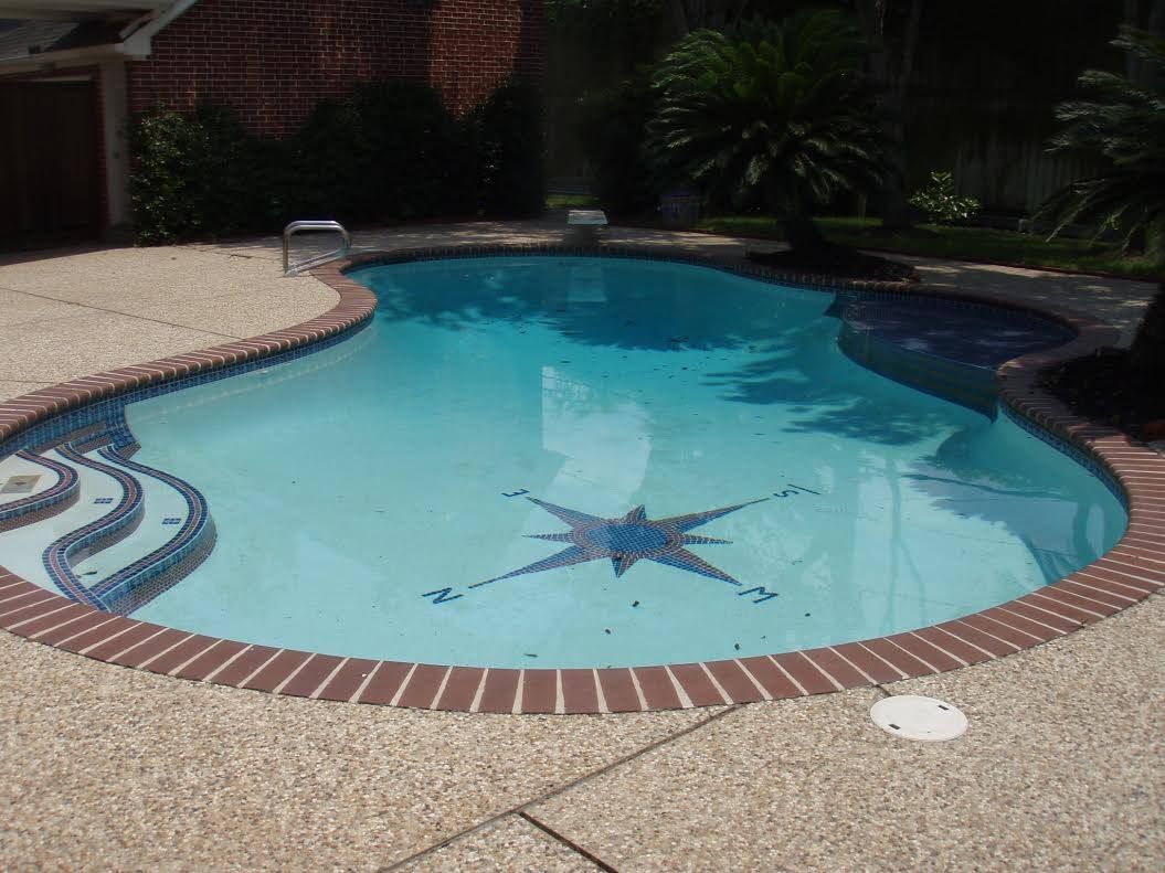 Backyard swimming pool with light blue water and a star mosaic in the center