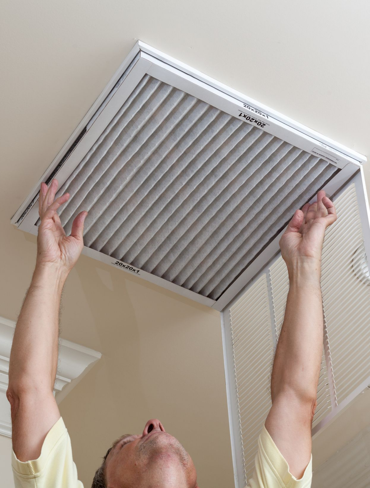Man opening ceiling air conditioning filter for home duct air care. Man opening ceiling air conditioning filter for home duct air care.