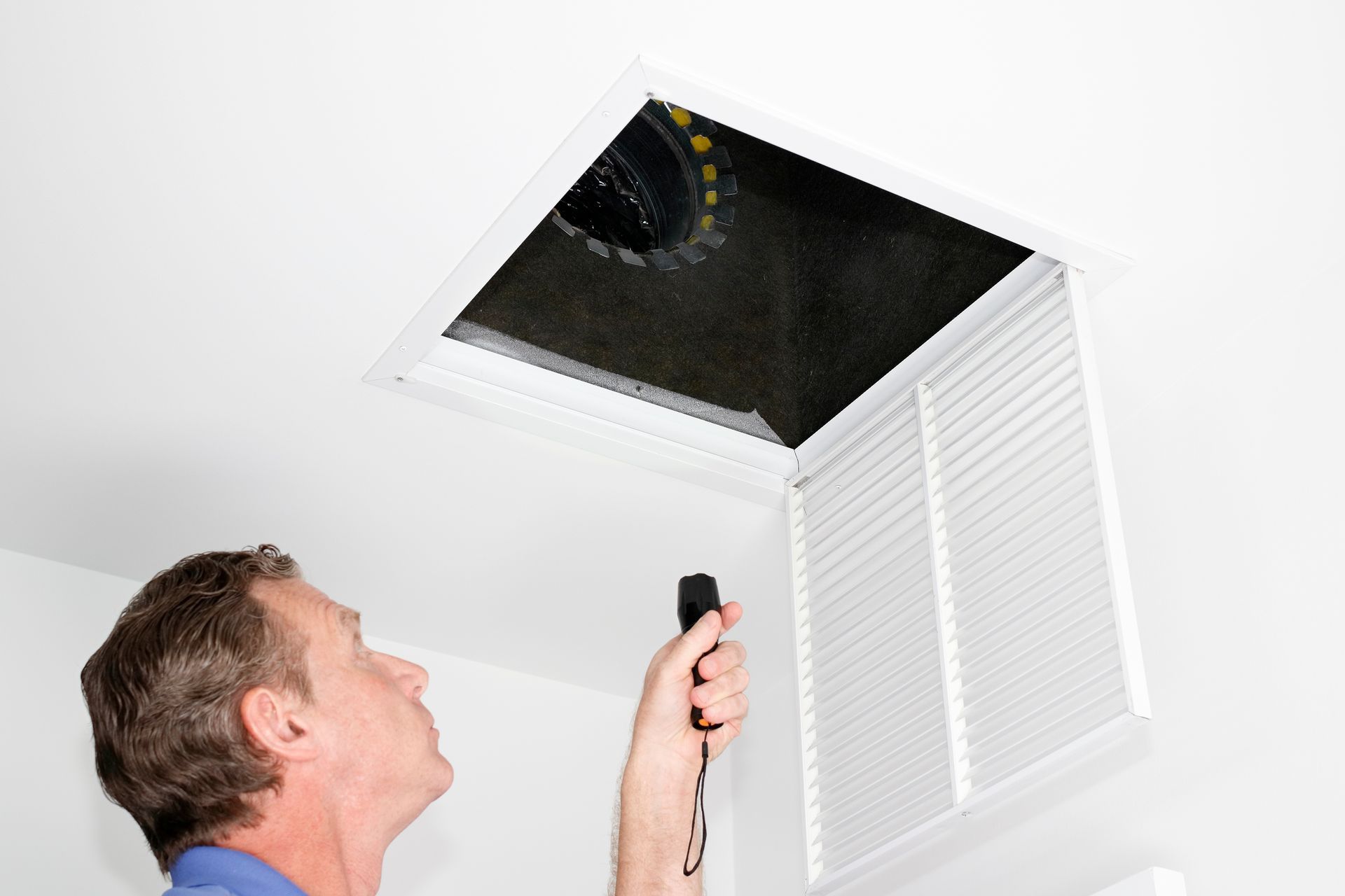 Air duct cleaning technician inspecting ducts for cleaning
