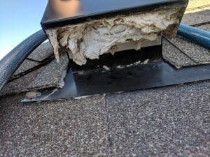A chimney on top of a roof with a lot of foam coming out of it.