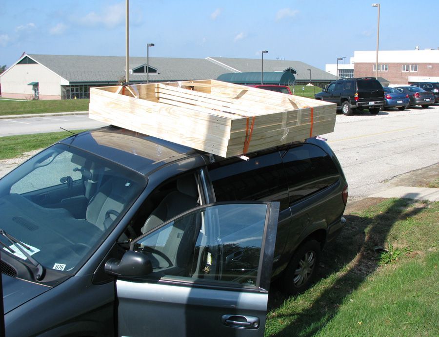 A van with a large wooden box on top of it