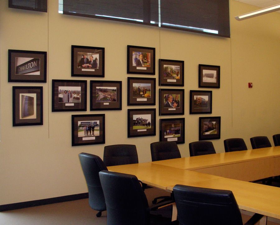 A conference room with a table and chairs and pictures on the wall