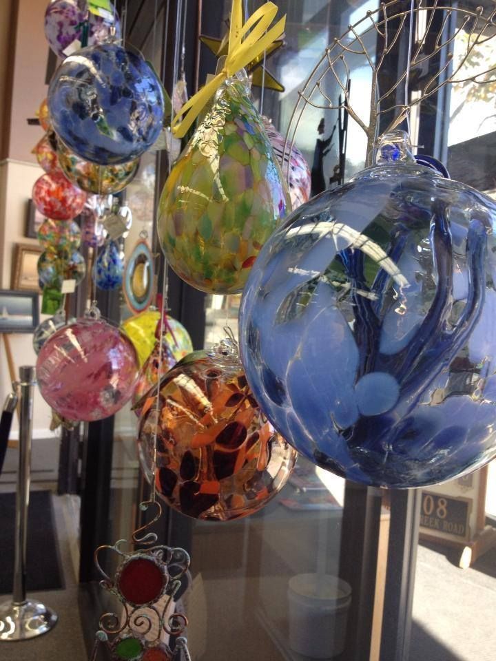A bunch of glass ornaments are hanging in a window