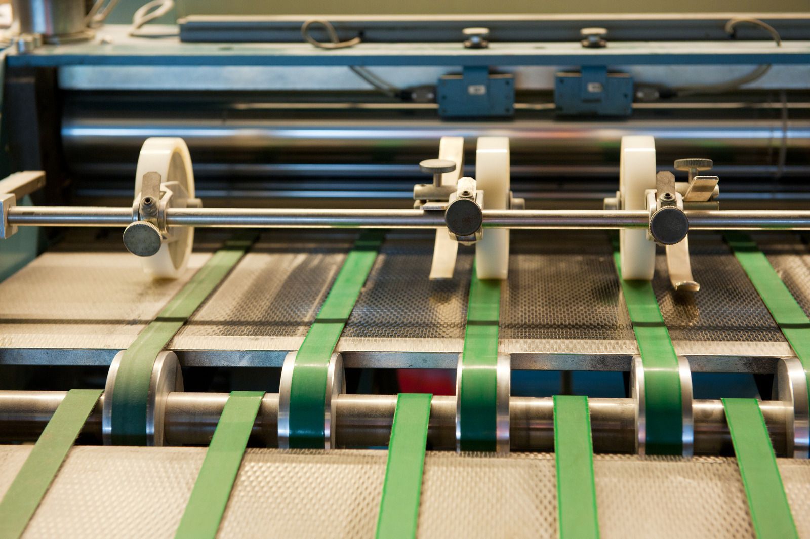 A machine is cutting a piece of paper with green tape.
