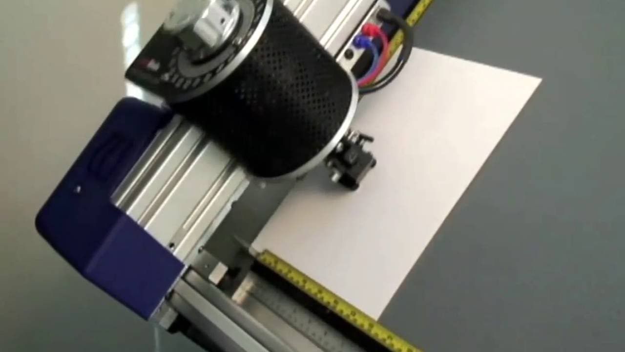 A machine is cutting a piece of paper on a table.