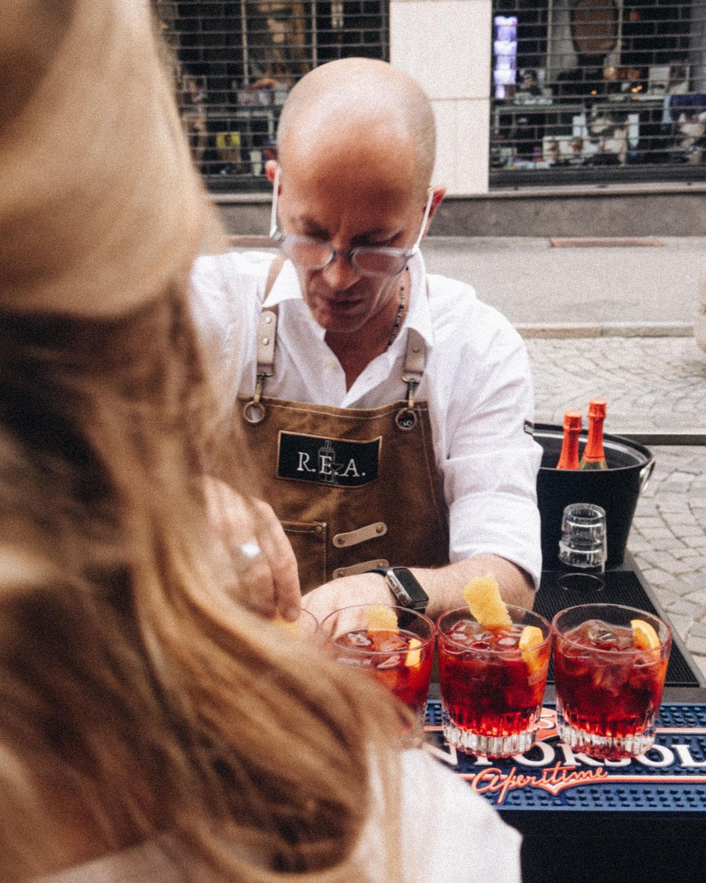 Venditore ambulante che prepara cocktail rossi con frutta su un bancone all'aperto