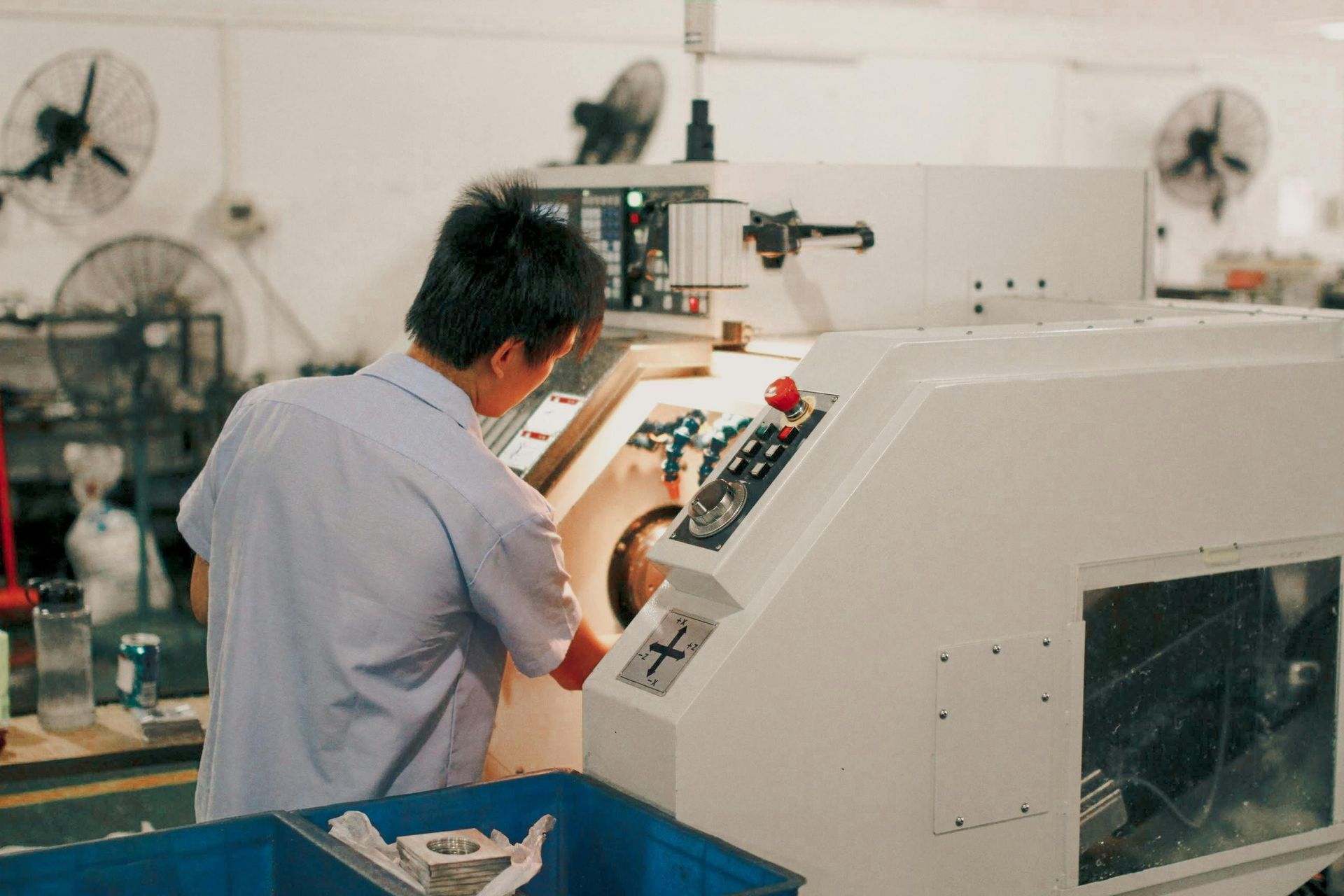 Um homem está trabalhando em uma máquina em uma fábrica.