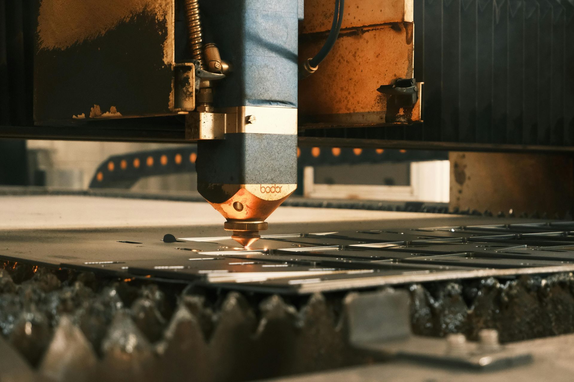 Uma máquina está cortando um pedaço de metal em uma fábrica.