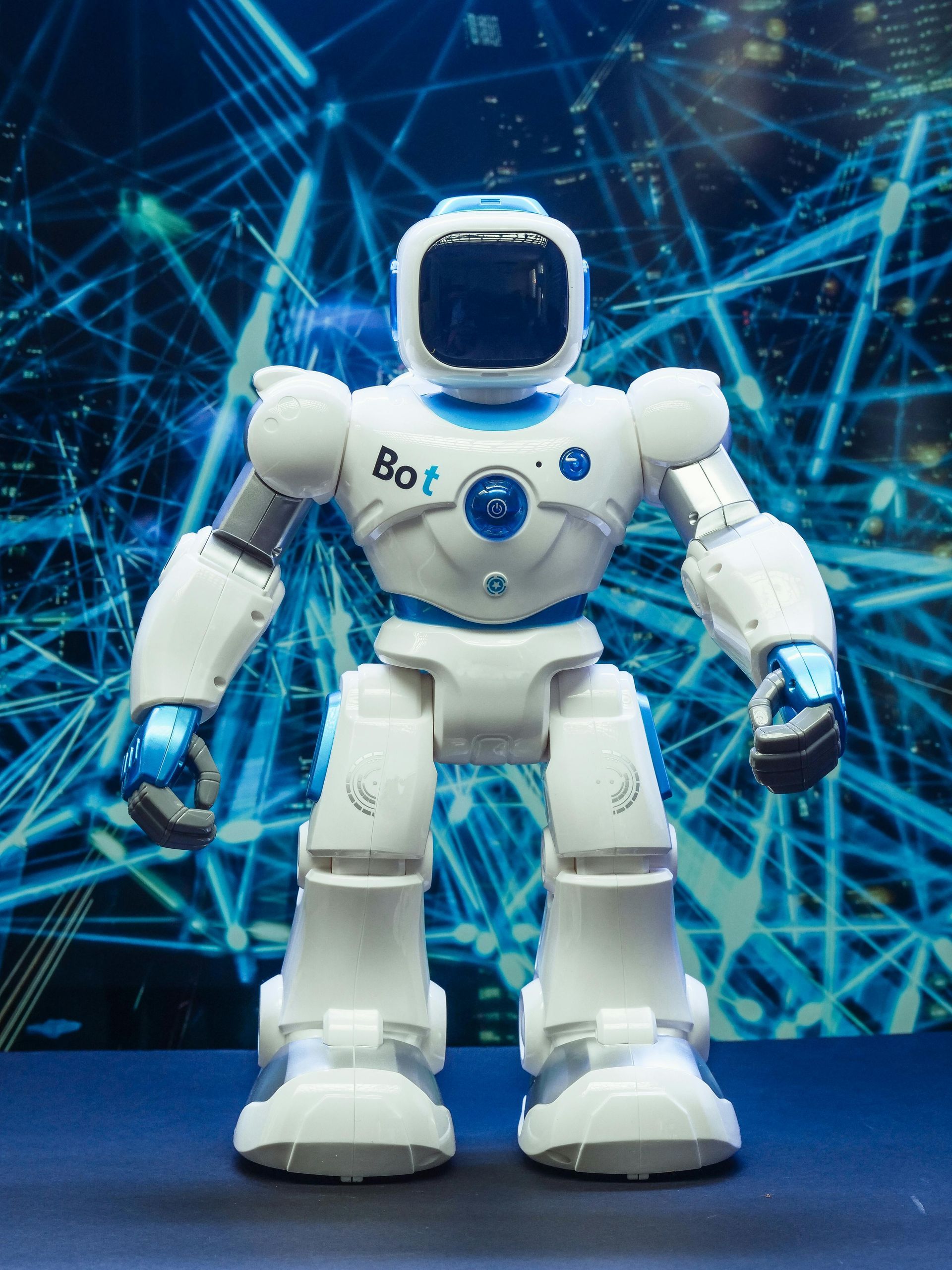 Um robô branco e azul está em uma superfície azul.
