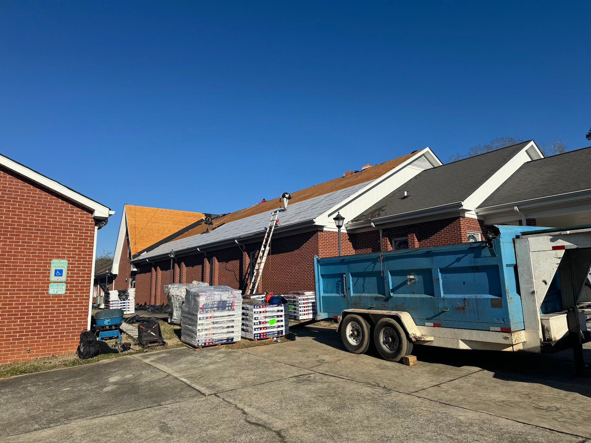 A dump truck is parked in front of a brick building.