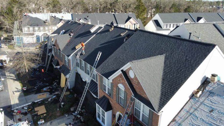 An aerial view of a row of houses with a roof being installed.